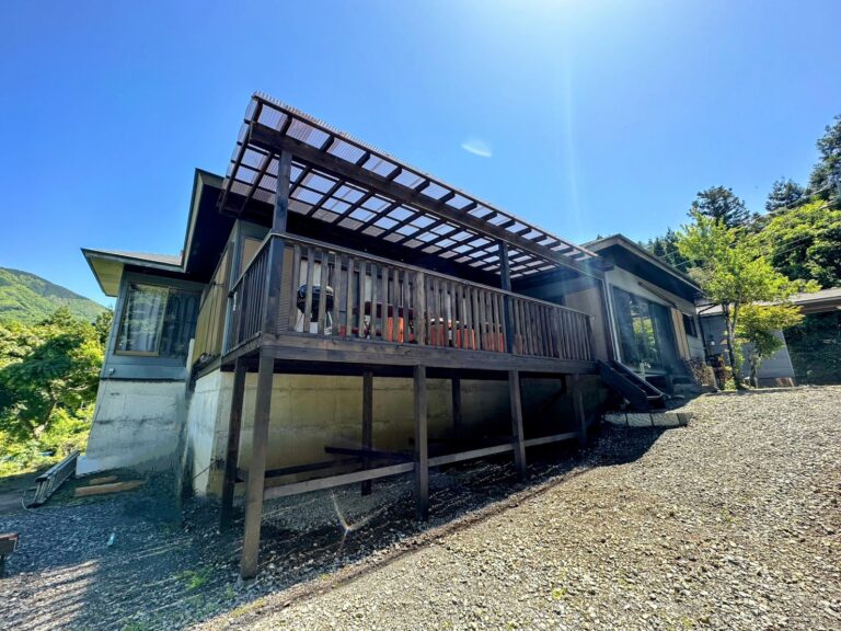 屋根付きウッドデッキの外観。BBQコンロとテーブルが見える